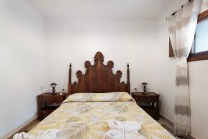 a bedroom with a bed with a wooden headboard at Casa Rural Medina 1 in Agulo