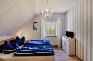 a bedroom with a bed with blue pillows and a window at Ferienhaus am Park in Heudeber