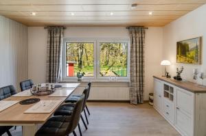 a dining room with a table and chairs and a window at Ferienhaus am Park in Heudeber
