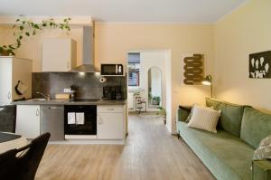 a living room with a green couch and a kitchen at Ferienhaus Berger 2025 in Bad Karlshafen