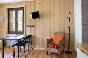 a room with a table and chairs and a television at Alta Valle Maira B in Acceglio