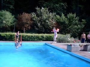 two people standing on a diving board in a swimming pool at Gästehaus Brigitte Schoch in Bad Rippoldsau-Schapbach