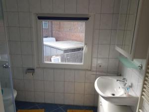 a small bathroom with a sink and a window at Haus Mara in Emden