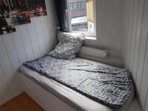 a small bed in a room with a window at Haus Mara in Emden +3 photos