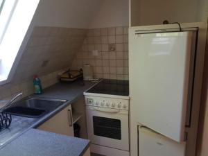 a kitchen with a white stove and a sink at Haus Mara in Emden