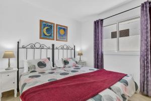 a bedroom with a large bed with purple curtains at Coqueto y tranquilo Apartamento in Puerto del Carmen