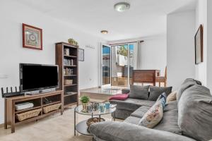 a living room with a couch and a tv at Coqueto y tranquilo Apartamento in Puerto del Carmen