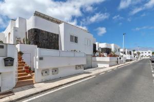 a white house on the side of a street at Coqueto y tranquilo Apartamento in Puerto del Carmen