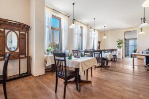 a dining room with tables and chairs and windows at Ferienwohnung im Hotel Reichskrone in Heidenau