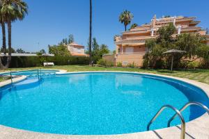 a large blue swimming pool in front of a building at Keops in Oliva