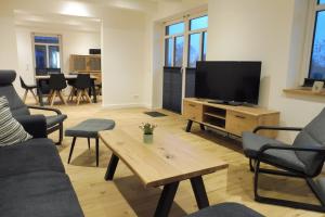 a living room with a couch and a television at Dat rode Huus in Oesterwurth