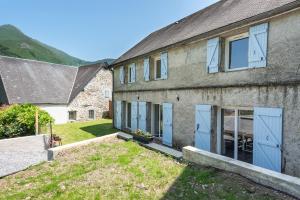 an old stone house with blue doors and a yard at Au Milan D'ore - Pyrénées in Gère-Belesten