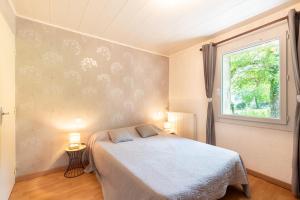 a bedroom with a bed and a window at Au Milan D'ore - Pyrénées in Gère-Belesten