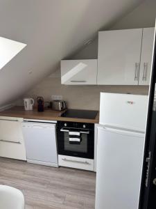 a kitchen with white cabinets and a stove and refrigerator at Appartement 3 morangis in Morangis