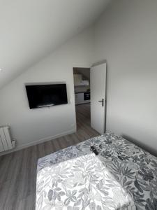 a bedroom with a bed and a flat screen tv at Appartement 3 morangis in Morangis +1 photo