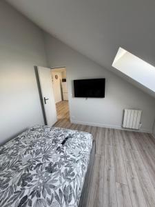 a bedroom with a bed and a flat screen tv at Appartement 3 morangis in Morangis