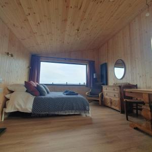a bedroom with a bed and a window and a desk at The Other Wee Red Cabin in Dunvegan