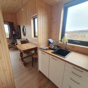 a kitchen with a sink and a table and a window at The Other Wee Red Cabin in Dunvegan +14 photos