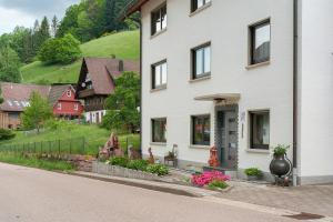 a white house with flowers in front of it at Gästehaus Gerda in Bad Peterstal-Griesbach