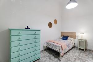 a bedroom with a blue dresser and a bed at La Casa de Tina in Playa de San Juan