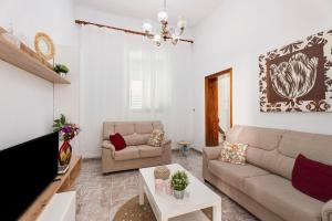 a living room with a couch and a tv at La Casa de Tina in Playa de San Juan