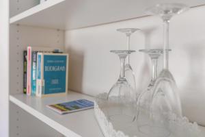 four empty wine glasses sitting on a shelf at Das weiße Stadthaus in Wesselburen