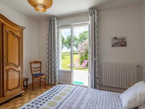 a bedroom with a bed and a window at Maison familiale terrasse et parc in Plouisy