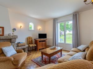 a living room with two couches and a tv at Maison familiale terrasse et parc in Plouisy