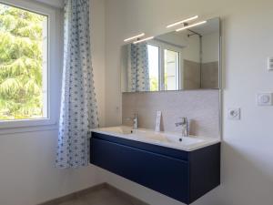 a bathroom with a sink and a mirror and a window at Maison familiale terrasse et parc in Plouisy +18 photos