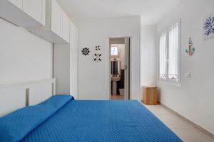 a bedroom with a blue bed in a white room at Montemare in Ameglia