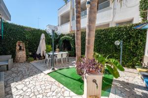 a garden with a table and a green lawn at Il Geco in Salice Salentino