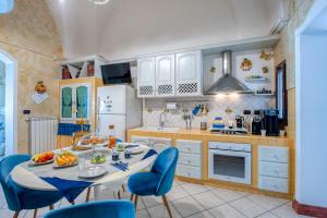 a kitchen with a table and blue chairs in it at Il Geco in Salice Salentino +36 photos