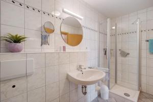 a white bathroom with a sink and a shower at Haus Am Weinberg 2 in Endingen +30 photos