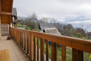 a wooden balcony with a view of a house at La Gelinotte - Jarrier in Jarrier