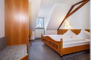 a bedroom with a bed with a wooden frame at Gasthof Adler in Ebenweiler