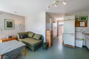 a living room with a couch and a refrigerator at Möve Aba Bungalow 61 in Rerik