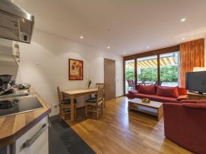 a kitchen and a living room with a red couch at Ferienwohnung Kobl in Immenstaad am Bodensee