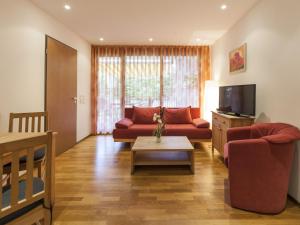 a living room with a red couch and a tv at Ferienwohnung Kobl in Immenstaad am Bodensee