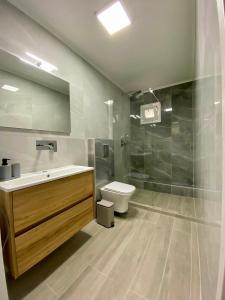 a bathroom with a sink and a toilet at Nikol's central suite 1 in Nea Peramos