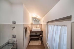 a bathroom with a sink and a mirror at Schnitzer Ferienwohnung Anemone in Rablà +15 photos