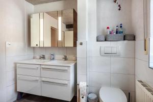 a white bathroom with a sink and a toilet at Ferienwohnung Fly in Wehr +14 photos