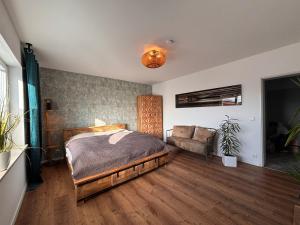 a bedroom with a bed and a couch at Fewo Dandelion in Haag