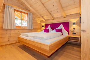 a bedroom with a bed in a wooden cabin at Blockhaus Ganschitter Großarl in Grossarl