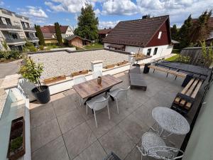 an outdoor patio with a wooden table and chairs at Fewo Dandelion in Haag
