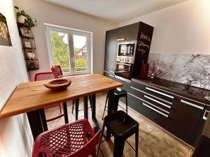 a kitchen with a wooden table and red chairs at Fewo Dandelion in Haag +7 photos