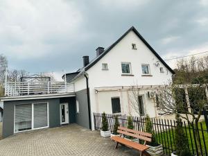a white house with a bench in front of it at Gasthaus Radków in Radków