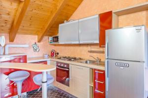 a small kitchen with a refrigerator and a table at Lovely Orange House in Viggiù