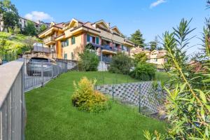 a yard with a fence and a house at Lovely Orange House in Viggiù