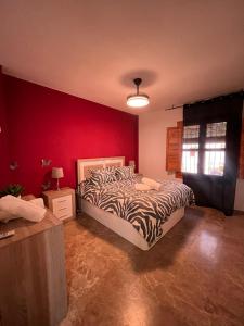 a bedroom with a bed and a red wall at La Casa Del Buda in Güéjar-Sierra