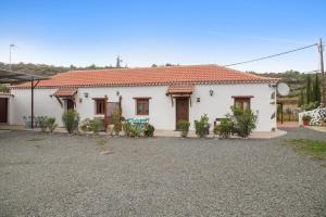 a white house with a driveway in front of it at La Tirajanera 1 in Vega de San Mateo